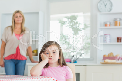 Child at kitchen table looking angry