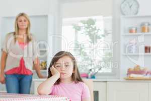Child at kitchen table looking angry