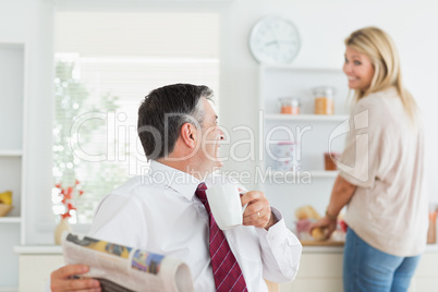 Couple laughing together in kitchen before work