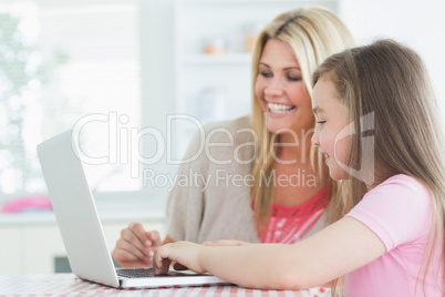 Woman and daughter sitting at the laptop
