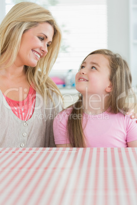 Mother and daughter looking at each other in the kitchen