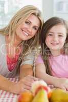 Mother and child sitting at kitchen table smiling