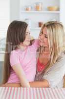 Mother and daughter looking lovingly at each other in kitchen