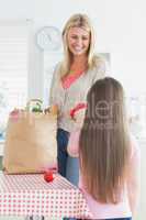 Mother and daughter unpacking grocery bag