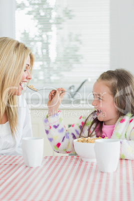 Girl feeding her mum cereal