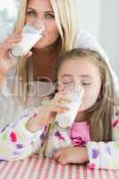Mother and little girl drinking milk