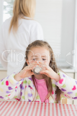 Child sitting drinking milk in the morning