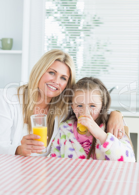 Woman and Child sitting at the kitchen table holding a glass of
