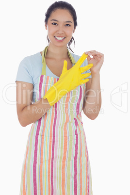 Woman in apron taking off rubber gloves