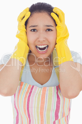 Stressed woman wearing rubber gloves and apron