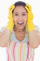 Stressed woman wearing rubber gloves and apron