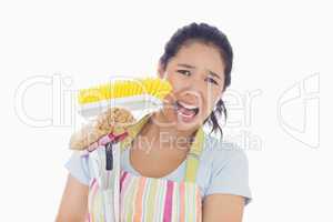 Frightened woman holding mop and a broom