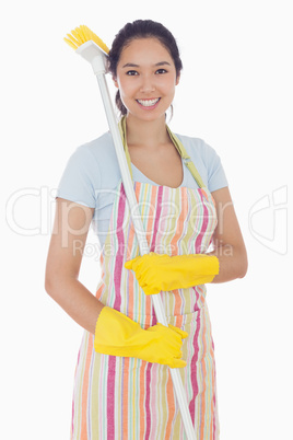 Smiling woman with a broom on her shoulder