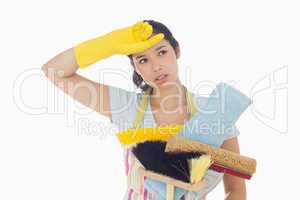 Weary woman holding cleaning tools