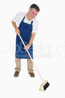 Happy man sweeping floor