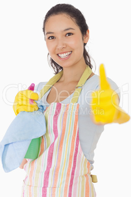 Woman holding cleaning products giving thumbs up
