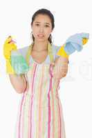 Overworked woman holding rag and spray bottle