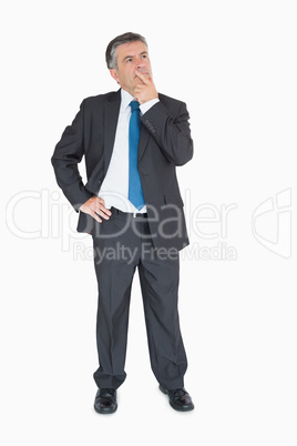 Businessman thinking with one hand on hip