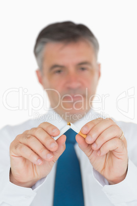 Businessman breaking a cigarette