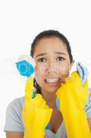 Stressed woman holding scrubbing brush and rag