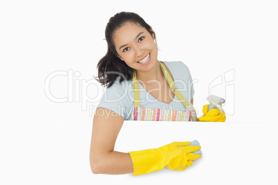 Happy woman wiping white surface