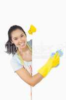 Smiling woman cleaning white surface