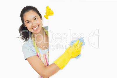 Cheerful woman cleaning white surface