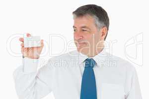 Man holding up and looking at his business card