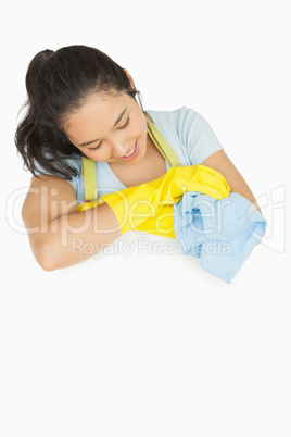 Happy woman with blue rag leaning on white surface