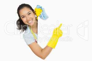 Woman in rubber gloves pointing to the white surface