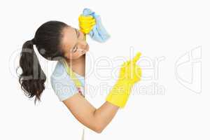 Happy woman pointing to white surface she is cleaning