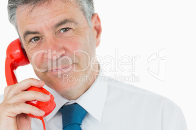 Businessman holding red phone
