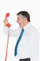 Businessman screaming directly into the handset