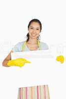 Woman in cleaning clothes pointing to white board she is holding
