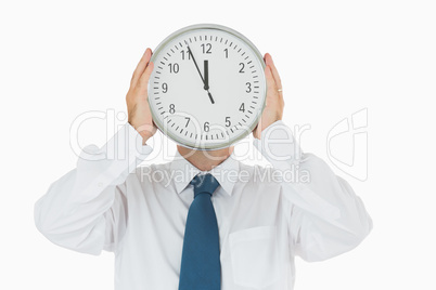 Man holding clock in front of face