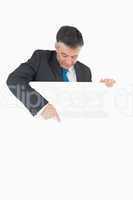 Man looking and pointing to white board he is holding