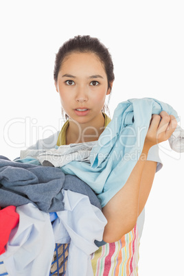 Tired woman holding dirty laundry