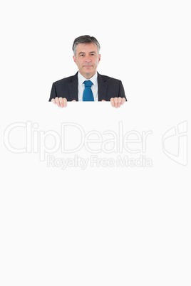 Smiling businessman looking over top of board