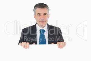 Thoughtful man standing behind white board