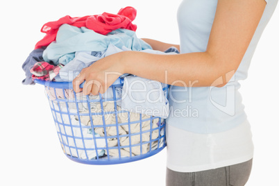 Woman holding a basket overflowing of laundry