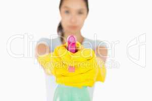 Serious woman pointing a spray bottle at the camera