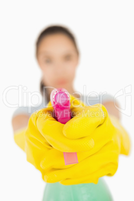 Confident woman pointing a spray bottle at the camera