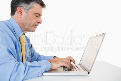 Concentrated man writing on laptop