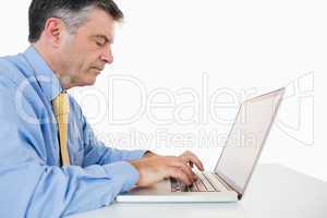 Concentrated man writing on laptop