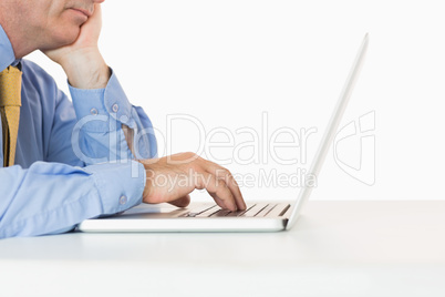 Well-dressed man writing on his laptop