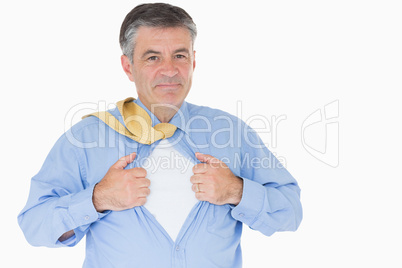 Businessman opening shirt like superhero