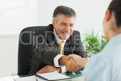 Man shaking a woman's hand in an office