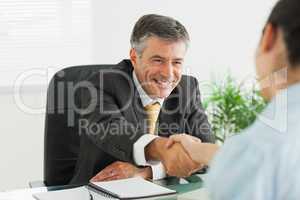 Man shaking a woman's hand in an office