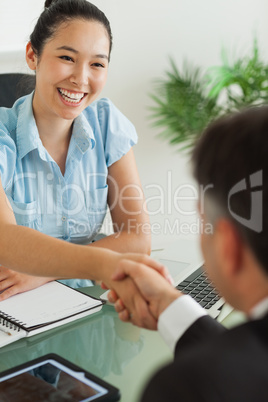 Smiling businesswoman shaking man's hand