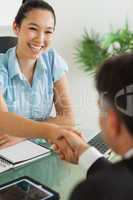 Smiling businesswoman shaking man's hand